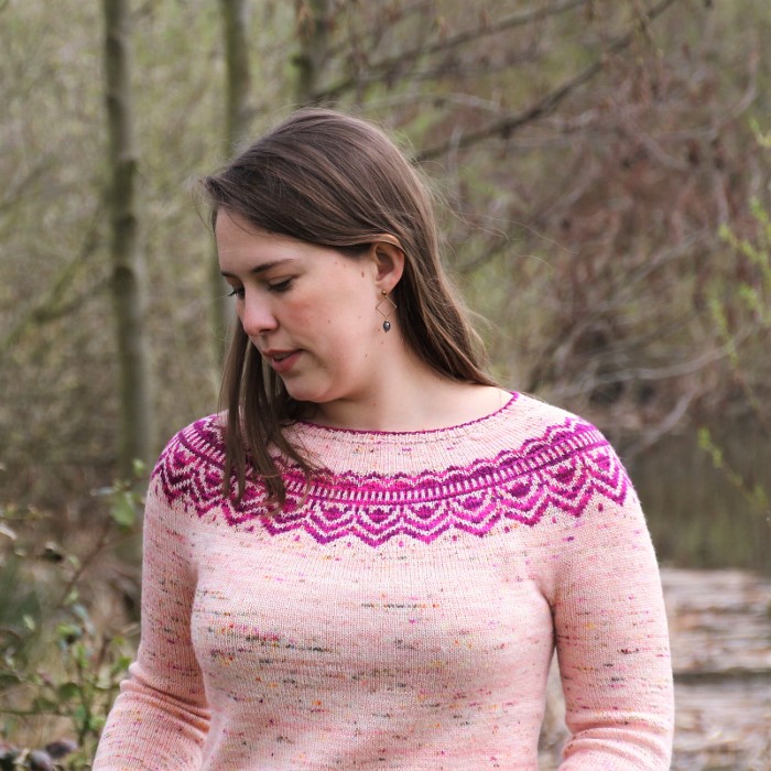 A close-up of Abenteuer sweater showing the beautiful circular yoke with a purple colorwork pattern.
