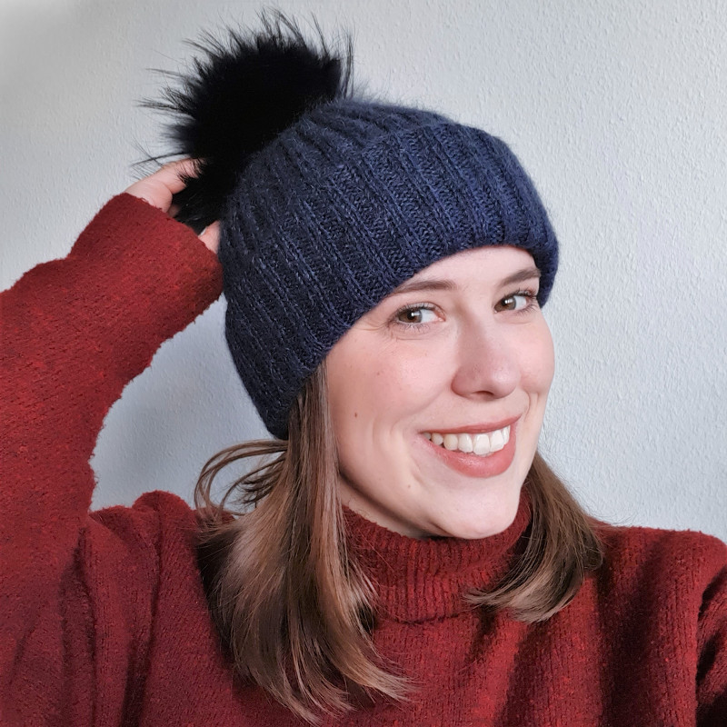 A super warm ribbed hat with three layers of fabric around the ears and a pompom.