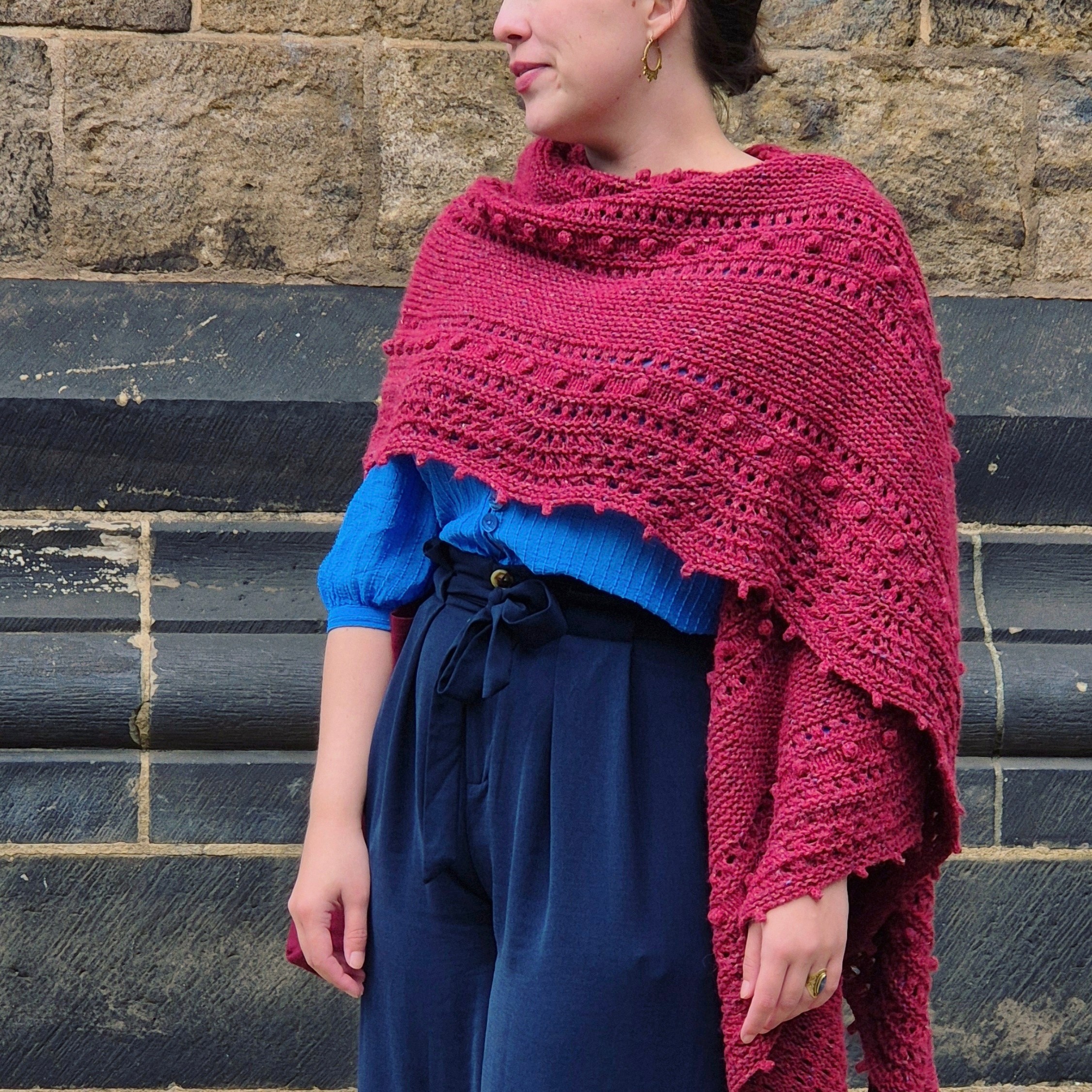  A crescent shapes shawl that comes in two sizes featuring a beautiful eyelet and bobble pattern and a ripple edge.